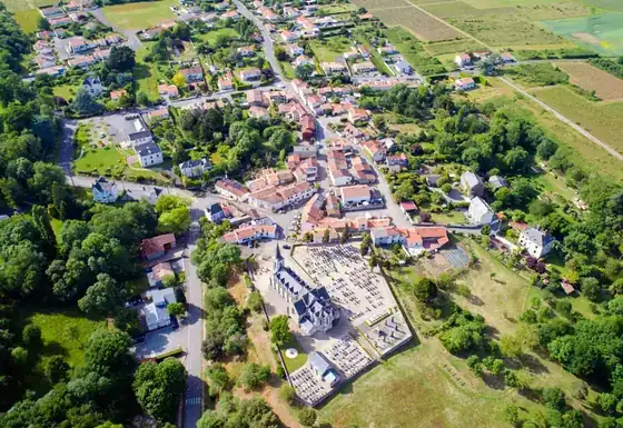 Vue aérienne d’un bourg avec son église, ses rues et ses lotissements