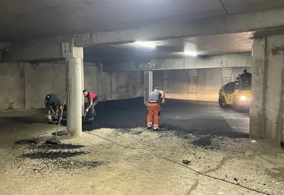 Équipe au travail avec un compacteur dans un parking couvert